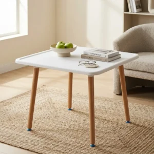 Small Indoor/Outdoor Dining Table with compact square white tabletop, four tapered angled wood-toned legs and small dark-toned feet