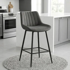 Grey Comfortable High Stool with upholstered cushioned seat, raised curved backrest, vertical stitched channels, dark metallic-toned four-leg frame and integrated footrest