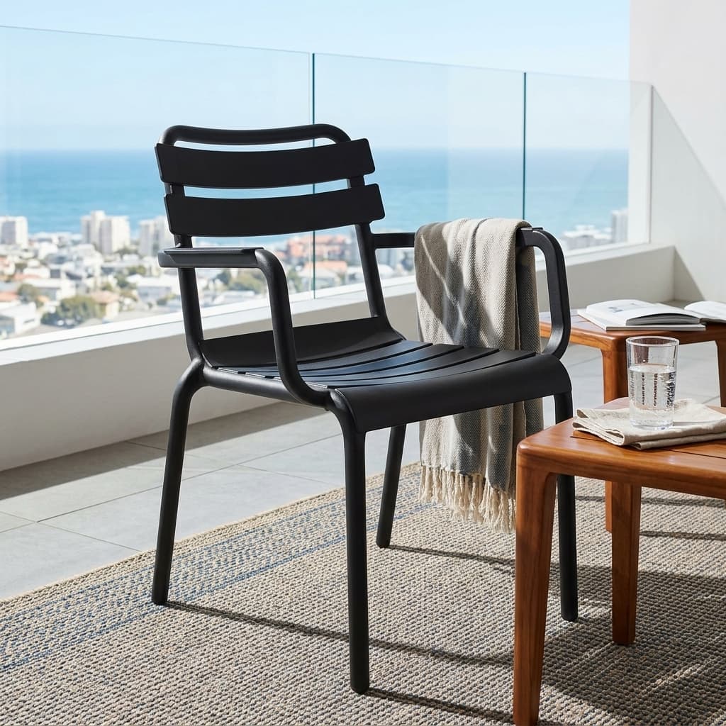 Stackable Plastic Dining Armchair Showcasing A Molded Black Polypropylene Frame, A Curved Slatted Backrest And Seat Pan With Horizontal Planks, And Integrated Loop Armrests.