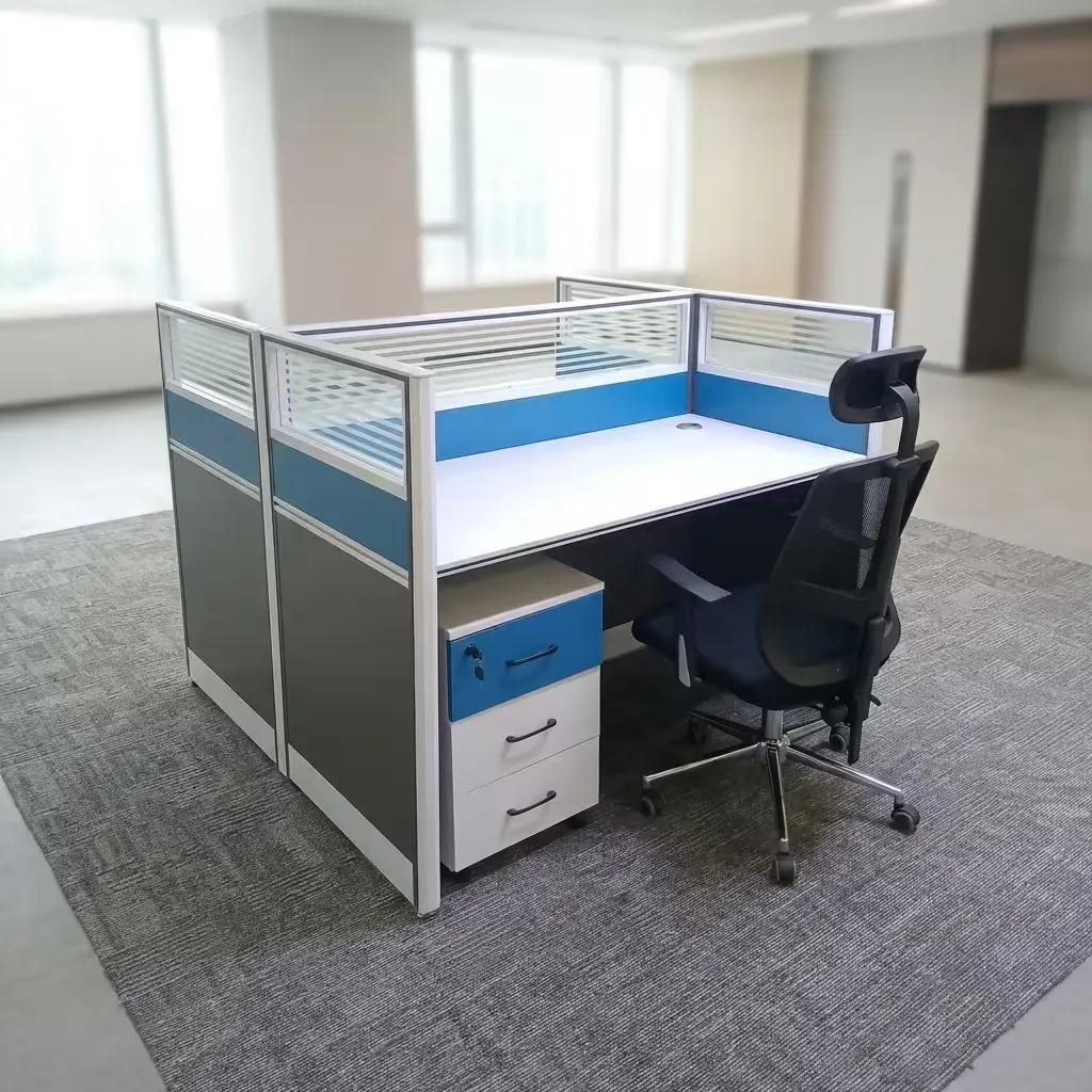 A Freestanding Modular Office Cubicle Configuration Featuring A White Desktop Surface, Blue And Gray Acoustic Privacy Panels, And A Matching Mobile File Drawer.