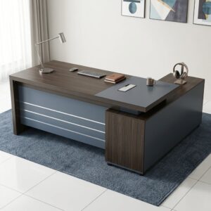 Executive Corner Desk with dark wood-grain engineered wood surfaces, contrasting charcoal panels, L-shaped desktop, integrated side storage, cable grommet, and full front modesty panel with metallic detailing.