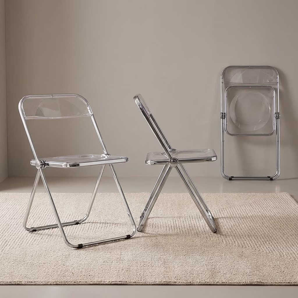 A Clear Acrylic Folding Chair Featuring A Transparent Plastic Seat And Backrest With A Shiny Polished Chrome Metal Folding Frame.