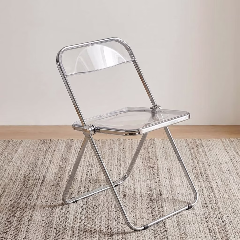 A Clear Acrylic Folding Chair Featuring A Transparent Plastic Seat And Backrest With A Shiny Polished Chrome Metal Folding Frame.