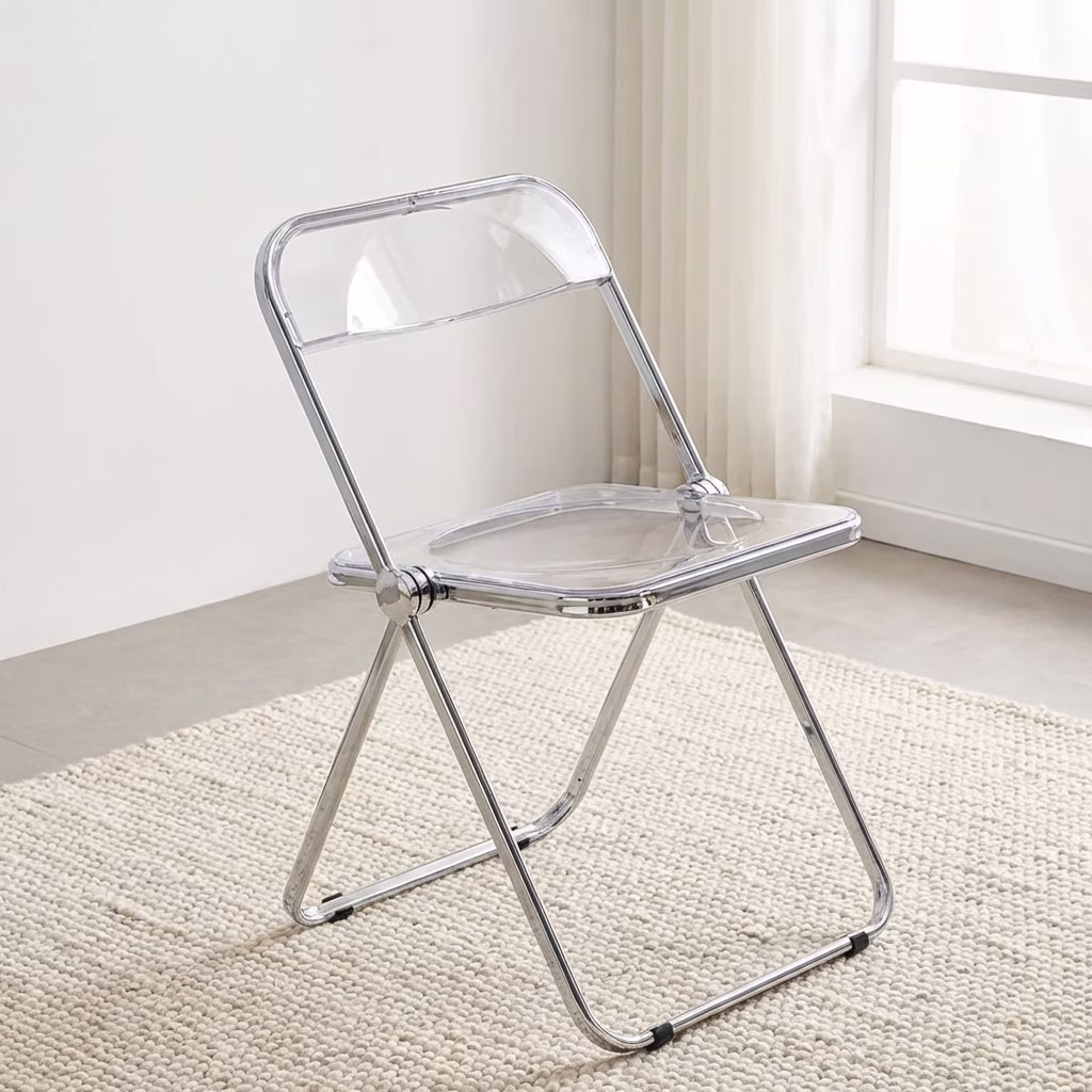 A Clear Acrylic Folding Chair Featuring A Transparent Plastic Seat And Backrest With A Shiny Polished Chrome Metal Folding Frame.