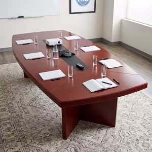 A boat-shaped 10ft Mahogany Office Boardroom Table featuring a rich reddish-brown wood grain finish, cross-panel legs, and a black center cable management track.