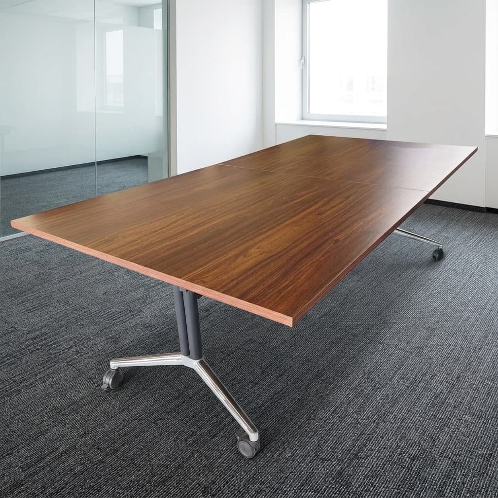 A Long Rectangular Mobile 2.4M Folding Boardroom Table Featuring A Walnut Wood Grain Finish Tabletop, Black Central Column Panels, And Polished Chrome T-Bar Legs With Dual-Wheel Locking Casters.